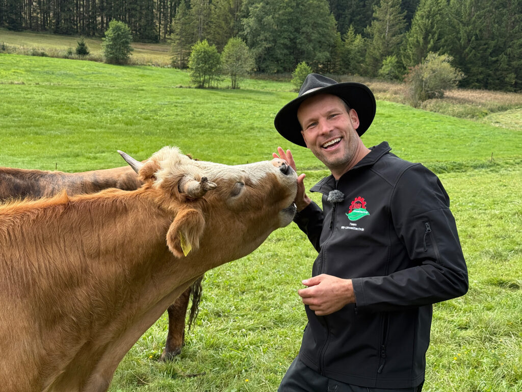 Max Bannaski auf einer Weide mit Kuh